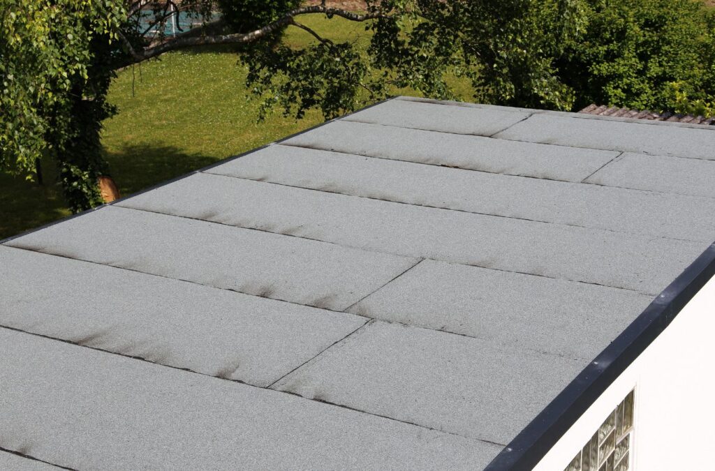 A Kings Roofing & Contracting roofer sealing a flat roof surface on a Nampa, ID building, ensuring strong waterproofing and long-lasting durability.