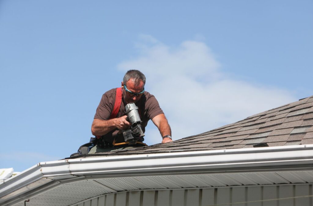 A Kings Roofing & Contracting roofer fixing lifted shingles on a Cascade, ID home, improving roof strength and preventing damage from changing seasonal weather.